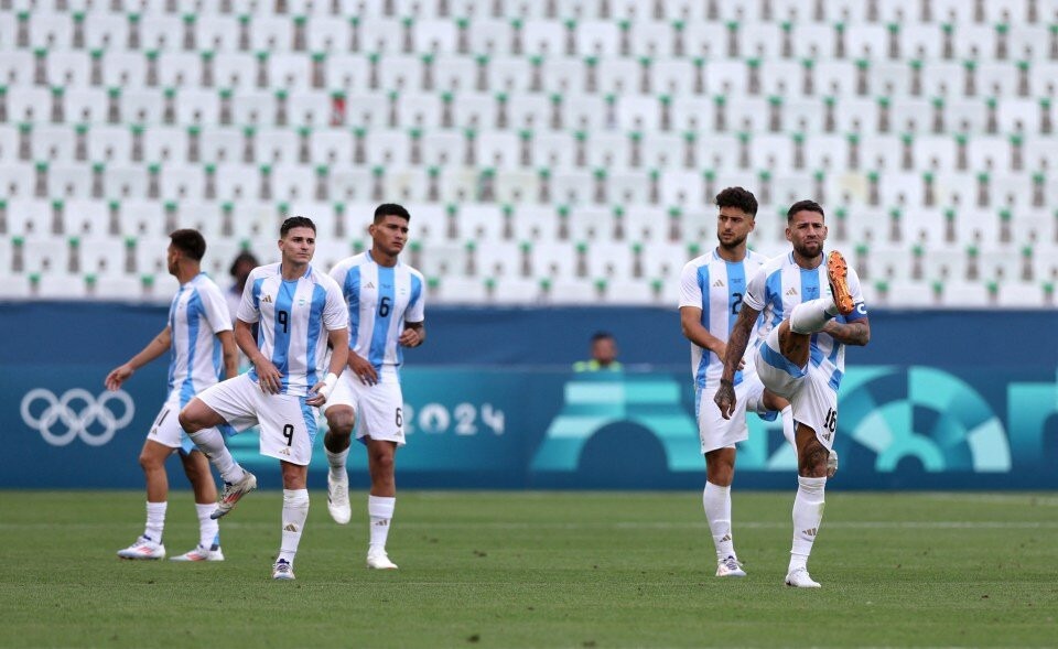 Cầu thủ Argentina vào sân Geoffroy-Guichard khởi động sau gần hai tiếng trận đấu tạm ngưng. Ảnh: Reuters